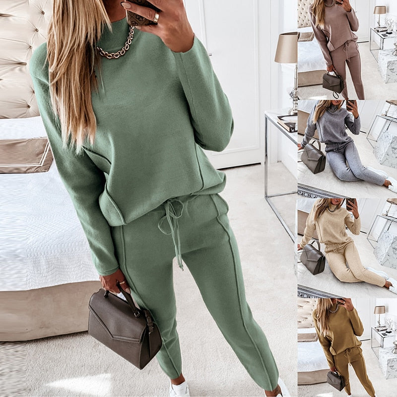 Frau in grünem Jogginganzug, hält braune Handtasche, Schlafzimmer, Mode, Freizeitkleidung.