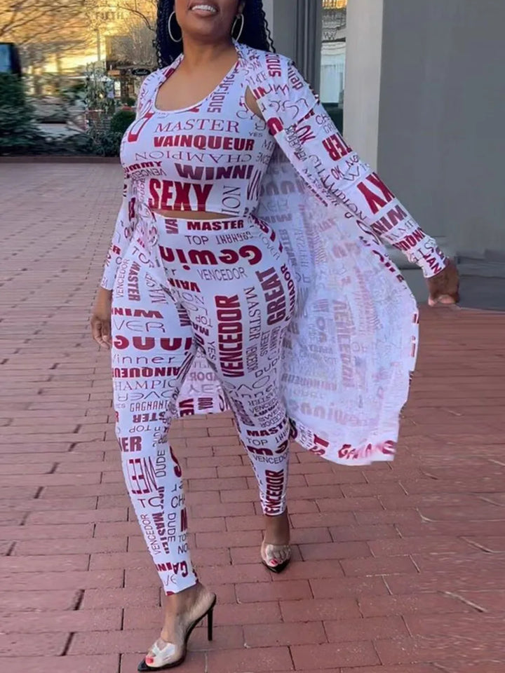 Frau in weißem Jumpsuit mit roten Schriftzügen, lange Ärmel, offener Cardigan, High Heels.