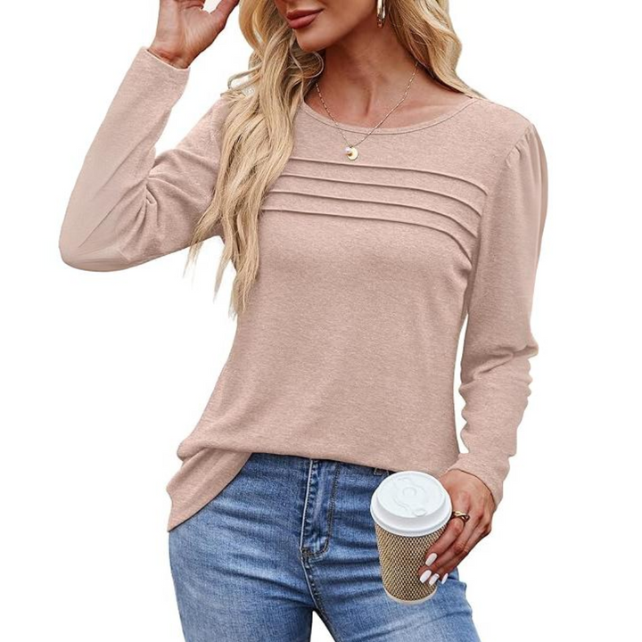 Frau in rosa Langarmshirt mit Kaffeebecher, blonde Haare, lässiger Look, modische Damenbekleidung.