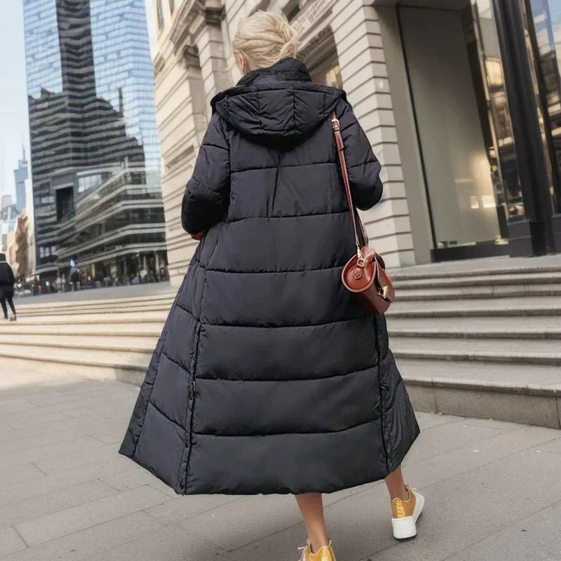 Frau in schwarzem Daunenmantel, Stadt, Wintermode, lange Jacke, Kapuze, braune Umhängetasche.