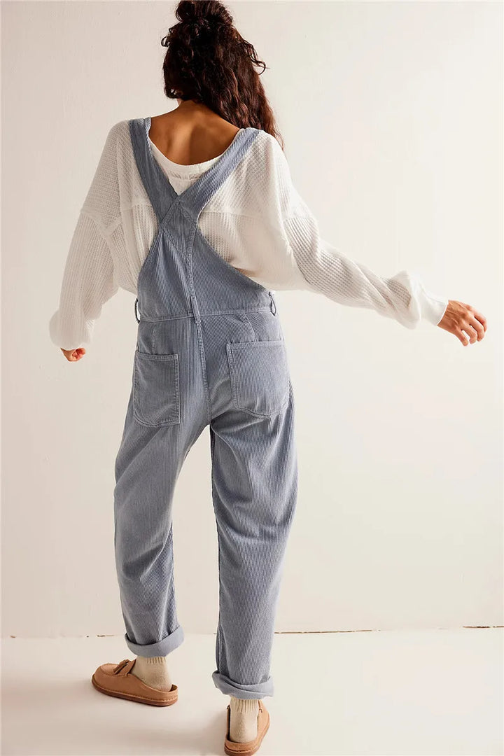 Frau in blauer Latzhose und weißem Pullover, lässige Mode, Rückansicht, Freizeitkleidung.
