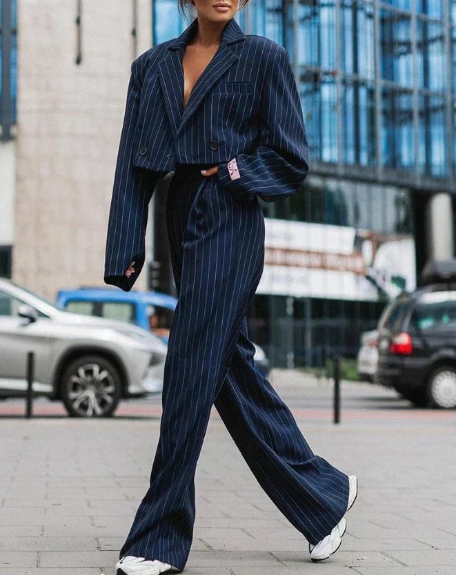 Frau in blauem Nadelstreifenanzug, urbaner Hintergrund, modisch, elegant, Streetstyle.