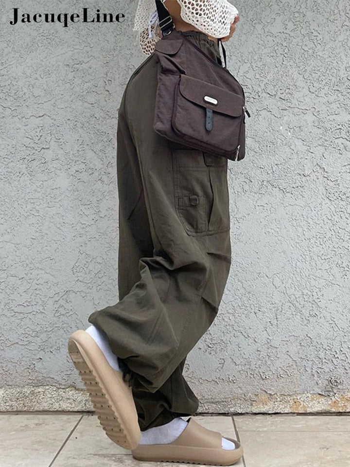Frau in olivgrüner Cargohose, braune Umhängetasche, beige Sandalen, lässiger Streetwear-Look.