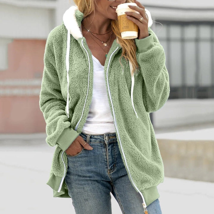 Frau in grünem Teddy-Fleece-Weste mit Reißverschluss, hält Kaffee, lässige Mode, Herbstbekleidung.