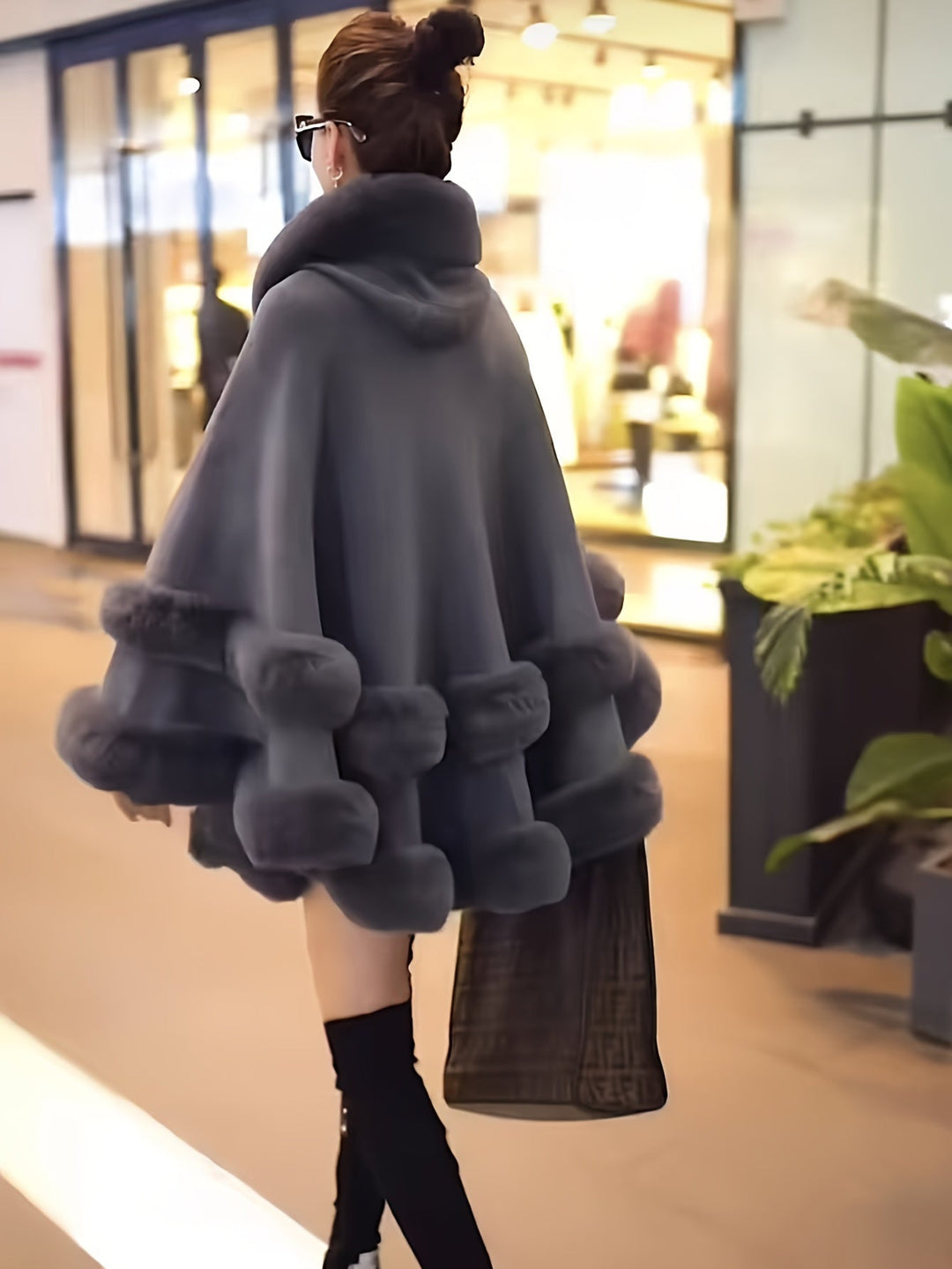 Frau in grauem Pelzmantel, trägt schwarze Stiefel, Einkaufszentrum, Mode, Winterkleidung