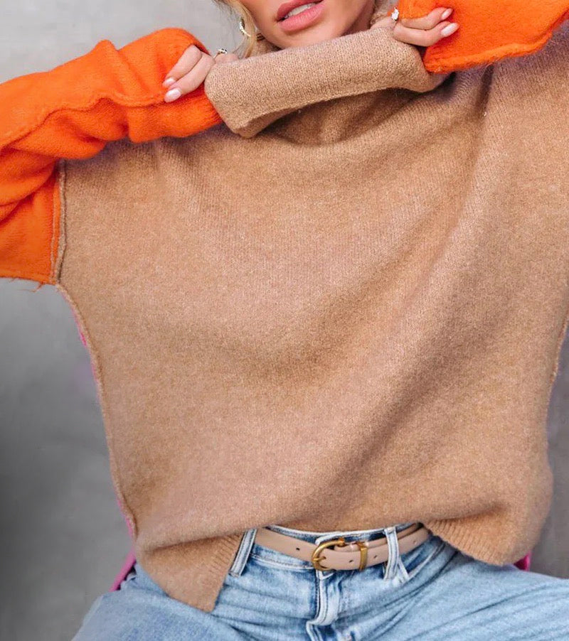 Frau trägt beige Pullover mit orangefarbenen Ärmeln, blaue Jeans, modisch, Herbstmode.