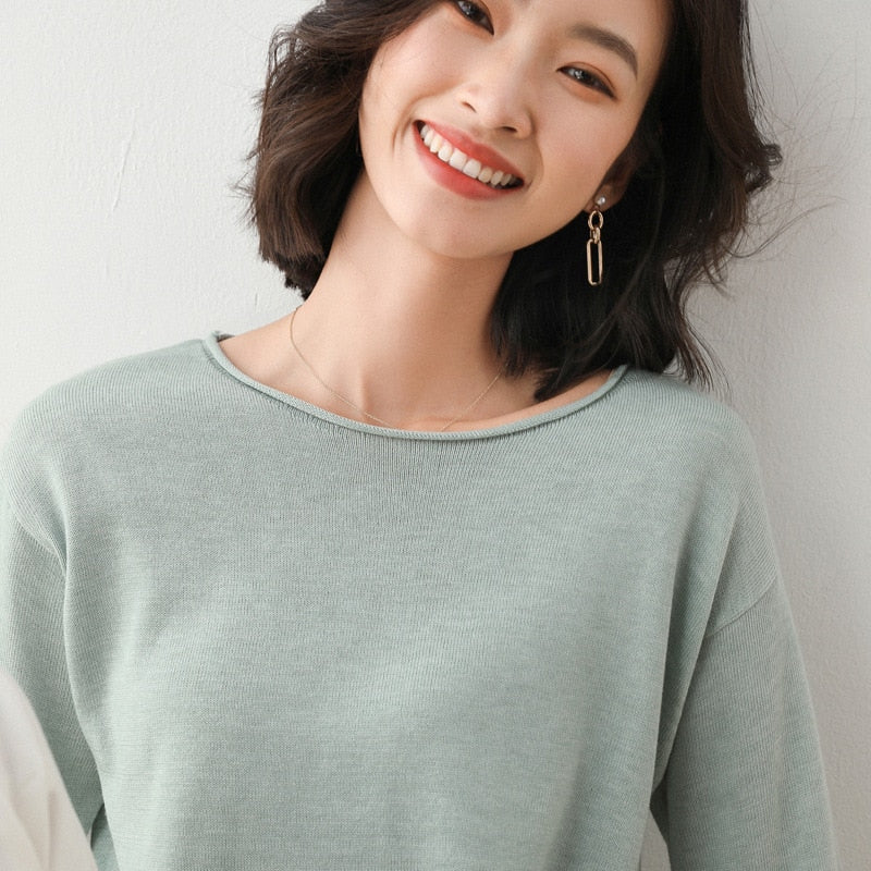 Frau in mintgrünem Pullover, lächelnd, mit Ohrringen, modisch, lässig, Damenmode.