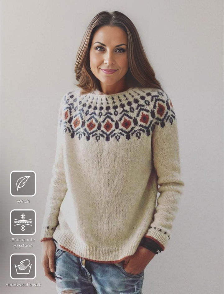 Frau in cremefarbenem Norwegerpullover mit Muster, weiches Material, entspannte Passform.
