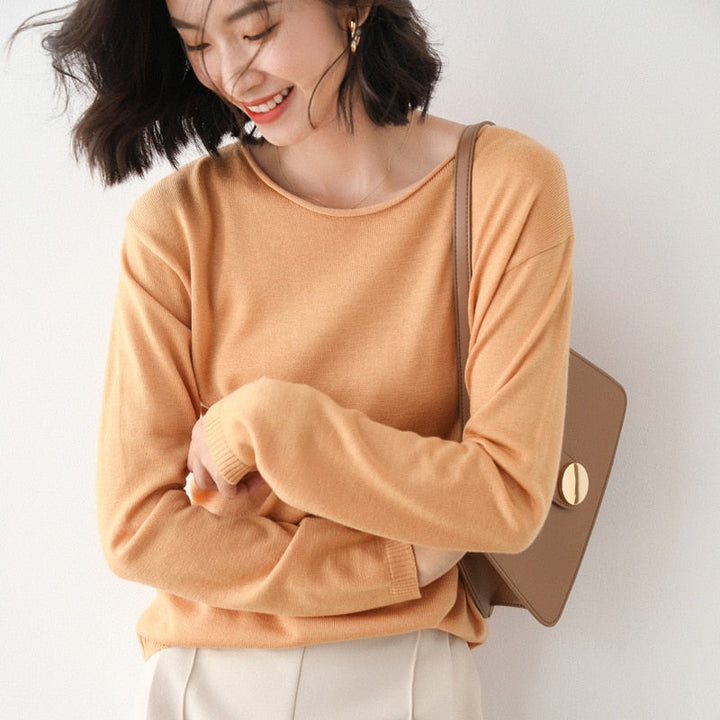 Frau in orangefarbenem Pullover mit brauner Tasche, lächelnd, modisch, Herbstmode.