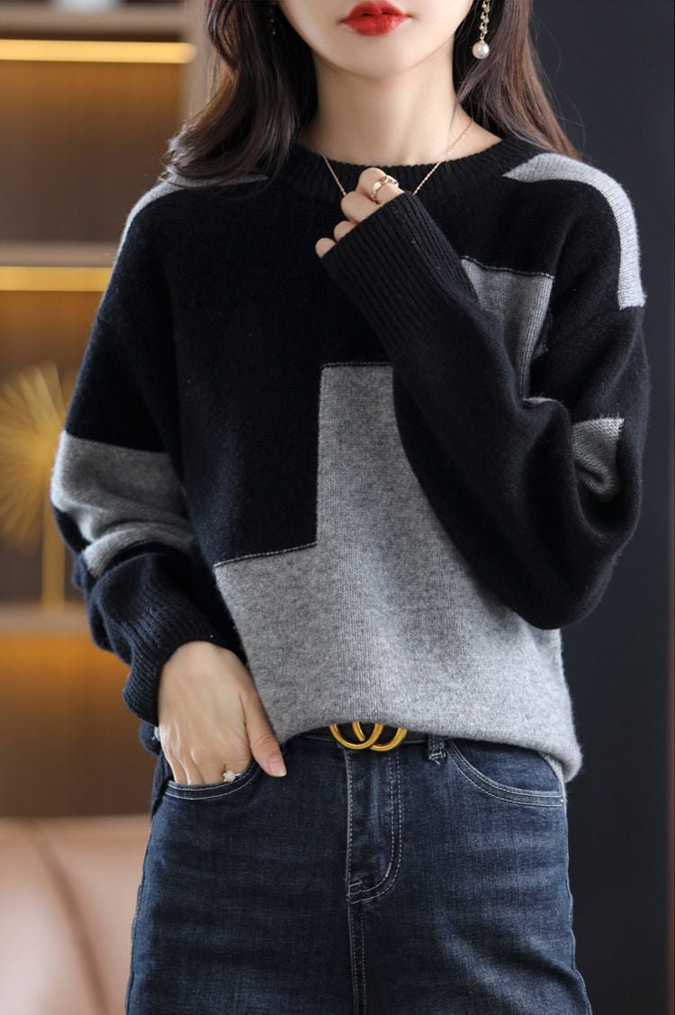 Frau trägt schwarz-grauen Pullover, Jeans, modisch, Herbstmode, Damenbekleidung, elegant.
