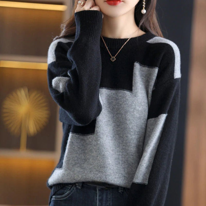 Frau trägt schwarz-grauen Pullover, geometrisches Muster, elegantes Design, Herbstmode.