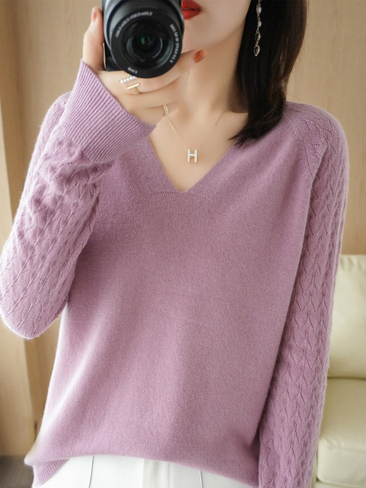Frau in lila V-Ausschnitt Pullover, Strickmuster, fotografiert mit Kamera, modisch, elegant.