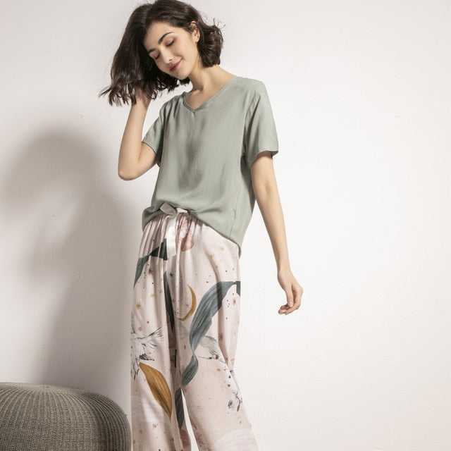 Frau in grünem T-Shirt und gemusterter Hose, lässige Damenmode, bequemes Outfit.