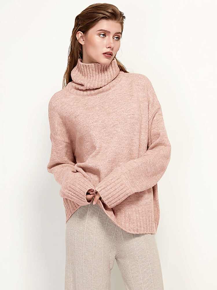 Frau in rosa Rollkragenpullover aus Wolle, lässig, modisch, Herbstmode, beige Hose.