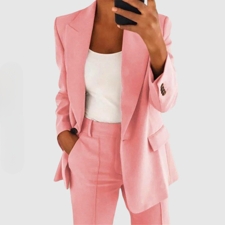 Frau im rosa Anzug mit weißem Top, Businessmode, eleganter Damenanzug, modisch, stilvoll.