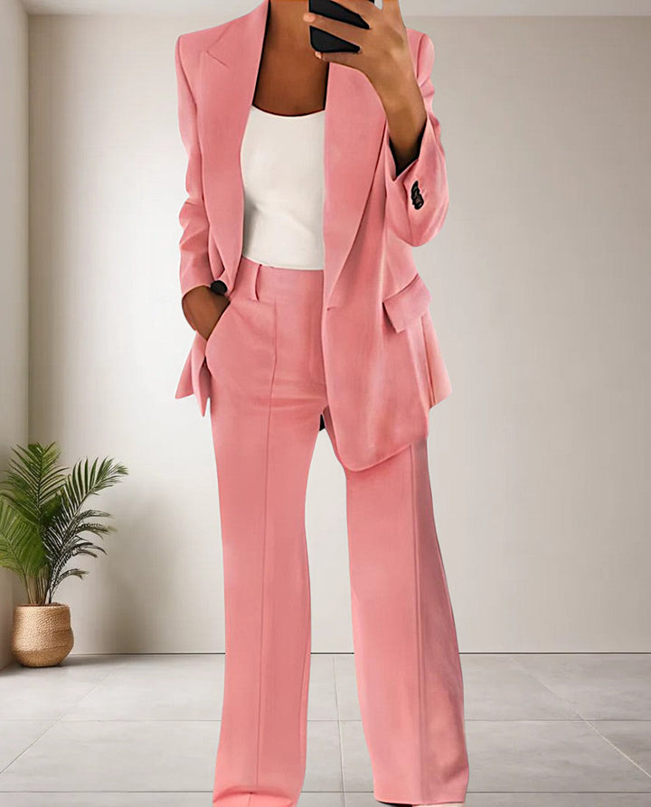 Frau im rosa Anzug, weißes Top, moderne Mode, eleganter Business-Look, Innenraum.