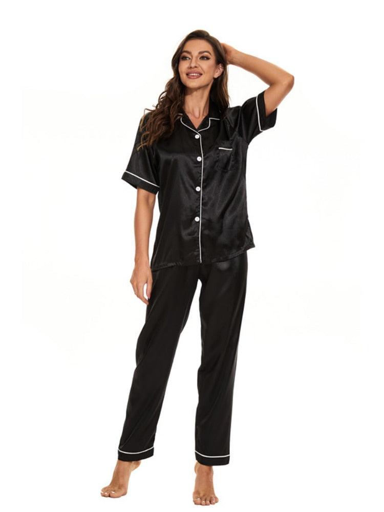 Frau in schwarzem Satin-Pyjama-Set, kurzärmeliges Hemd, lange Hose, Nachtwäsche.