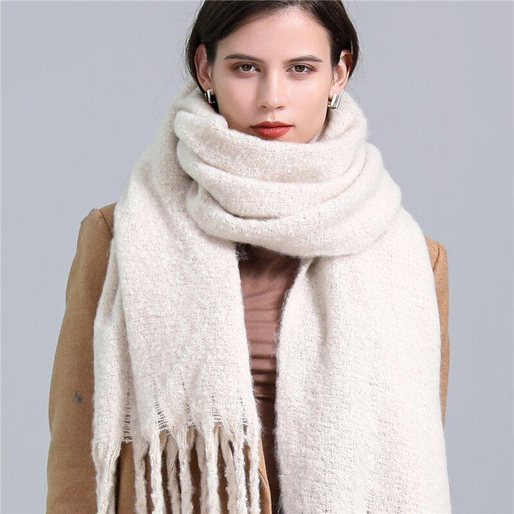 Frau mit cremefarbenem Wollschal, elegant, warm, Wintermode, Damenaccessoire, stilvoll.