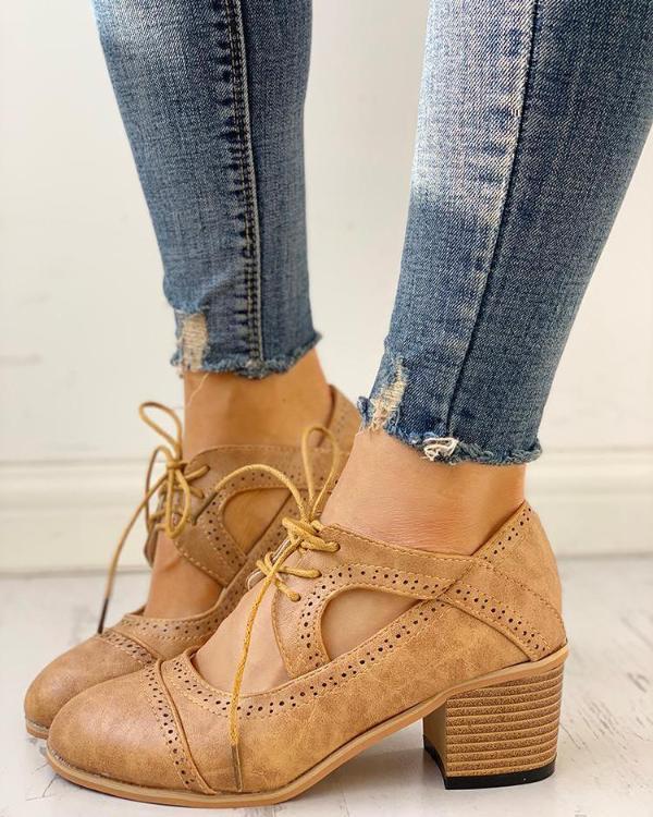 Damen Oxfordschuhe aus braunem Leder mit Blockabsatz, kombiniert mit zerrissenen Jeans.