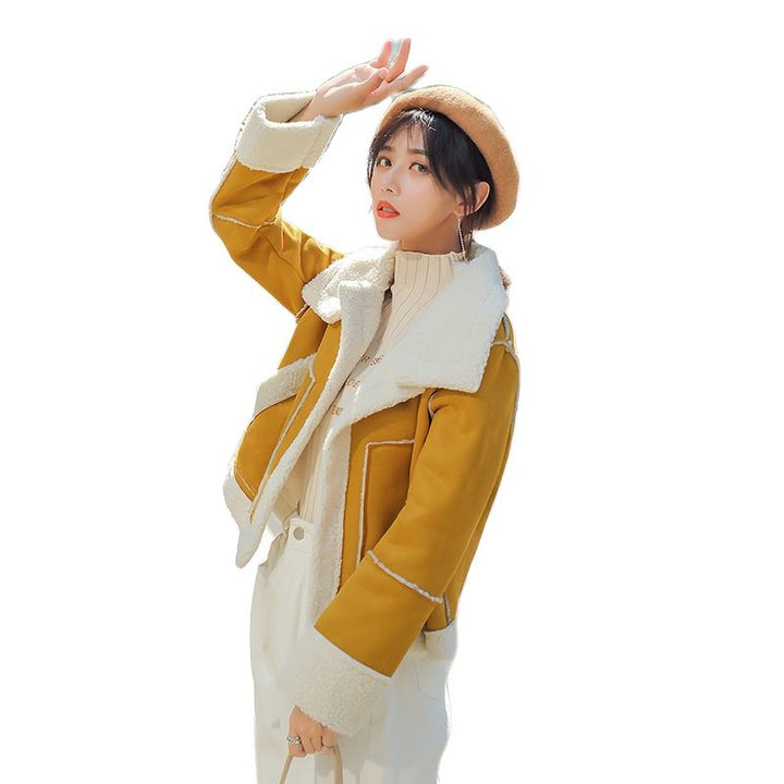Frau in gelber Lammfelljacke, weißem Rollkragenpullover und beiger Baskenmütze, modisch.