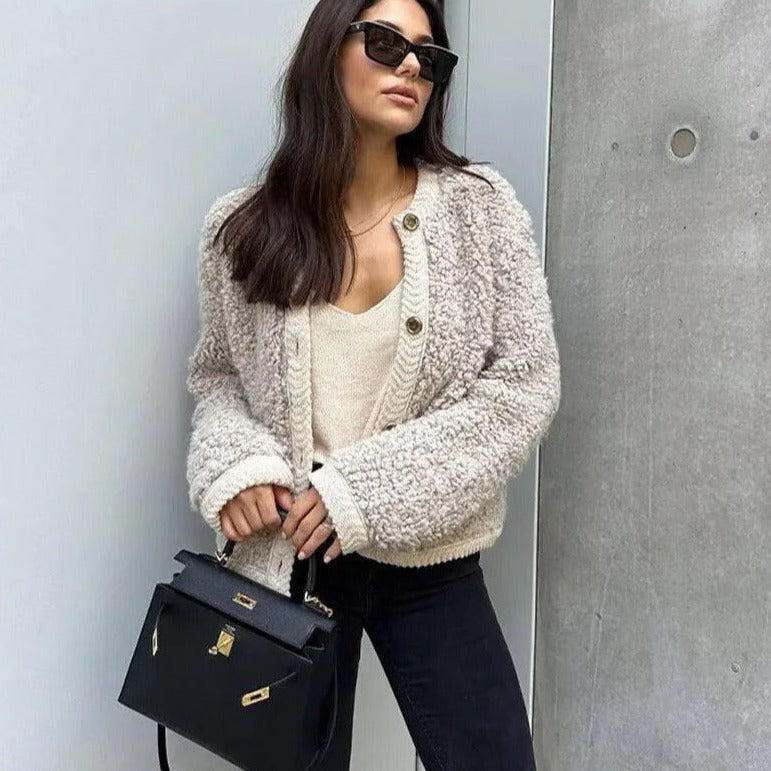Frau in beiger Teddyjacke, schwarze Sonnenbrille, schwarze Handtasche, lässiger Look, Mode.