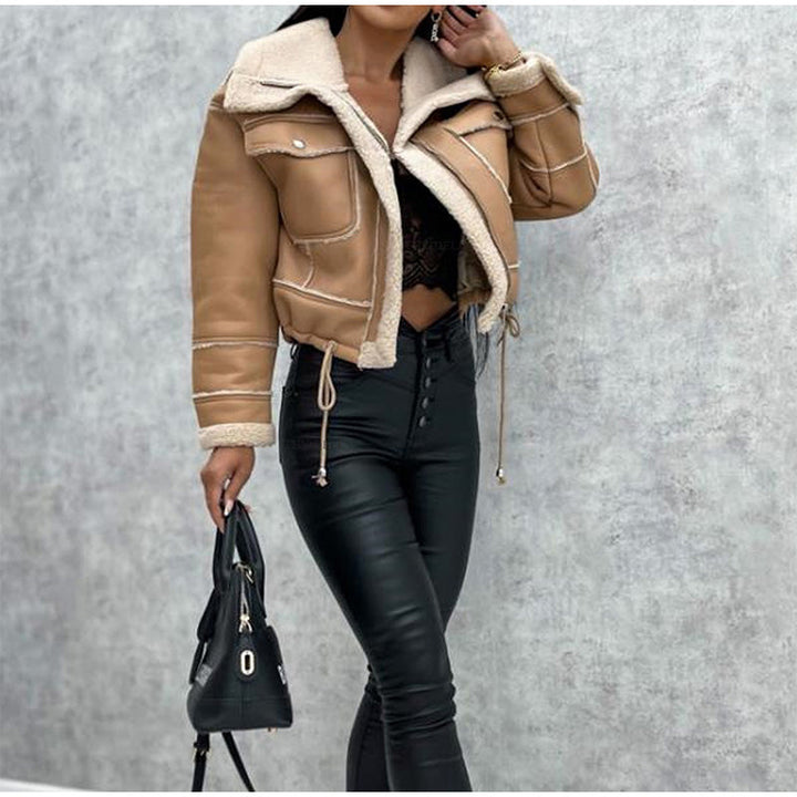 Frau in brauner Lederjacke mit Sherpa-Futter, schwarze Hose, Handtasche, modisch, Herbstmode.
