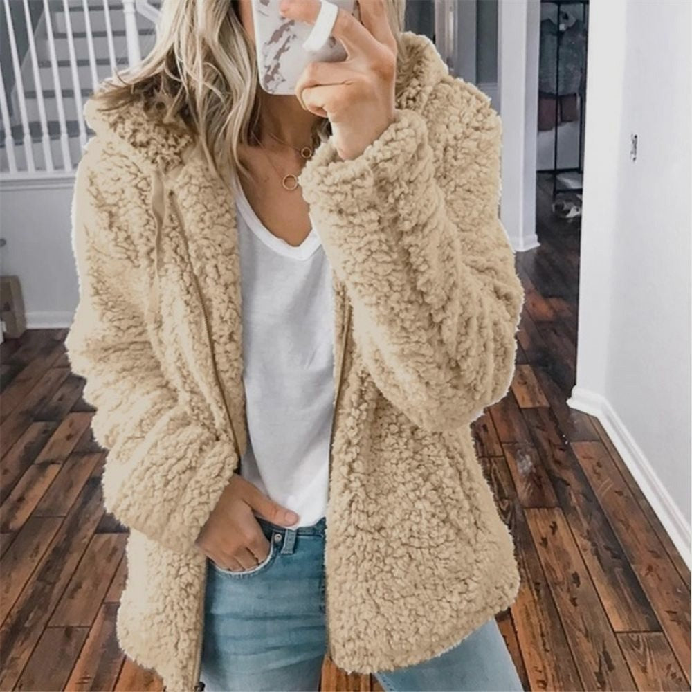 Frau in beiger Teddyjacke, weißem T-Shirt und Jeans, modisch, gemütlich, Herbstmode.