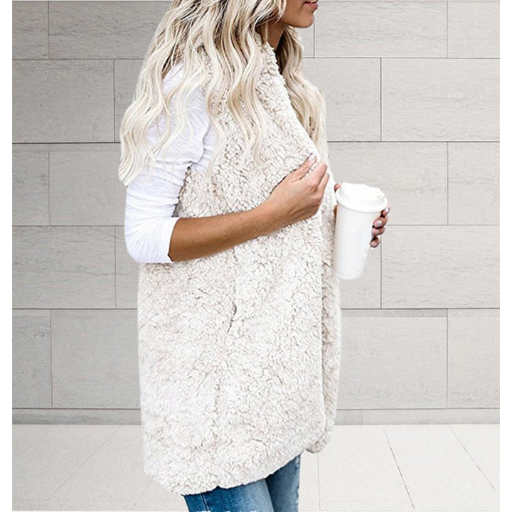 Frau in weißer Teddyfell-Weste mit Kaffeebecher, lässige Mode, Herbst-Winter-Outfit.