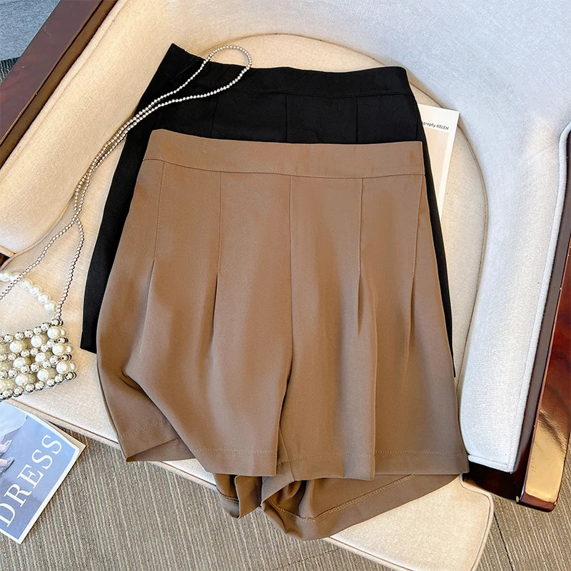 Braune und schwarze Damen-Shorts aus Baumwolle auf einem Sessel, elegante Sommermode.