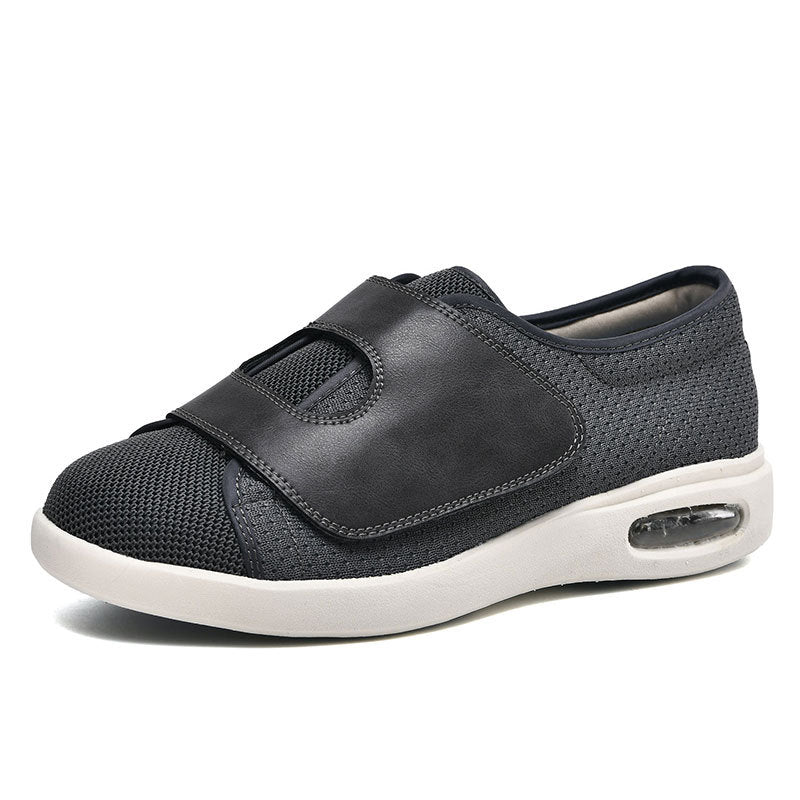 Dunkelgrauer orthopädischer Schuh mit Klettverschluss, atmungsaktivem Mesh und Luftpolstersohle.