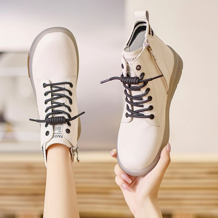 Weiße Damen-Sneaker aus Leder, wasserdicht, hohe Passform, schwarze Schnürsenkel.