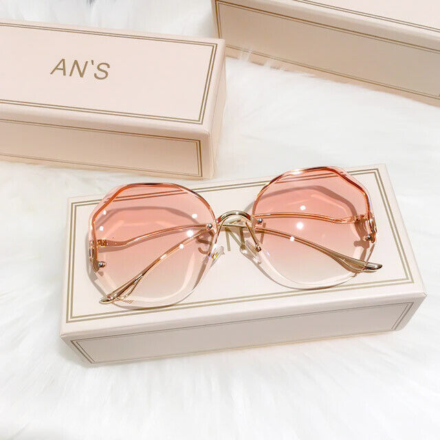 Rosafarbene Sonnenbrille mit goldenen Bügeln auf weißem Hintergrund, modisches Accessoire.