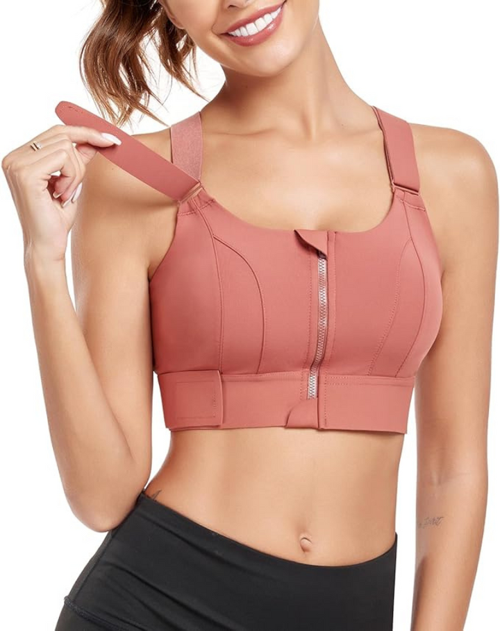 Frau in rosa Sport-BH mit Reißverschluss, verstellbaren Trägern, ideal für Fitness und Yoga.