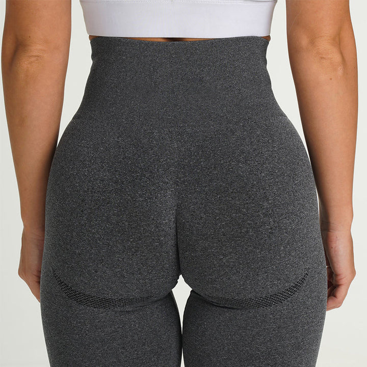 Frau in grauer, nahtloser Sportleggings, Rückansicht, hohe Taille, Fitnessmode.