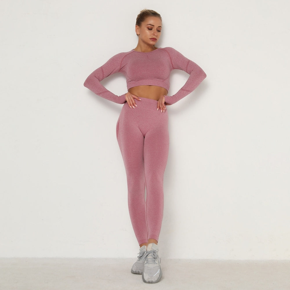 Frau in rosa nahtlosem Sport-Set, Langarm-Top und Leggings, Fitnessmode.