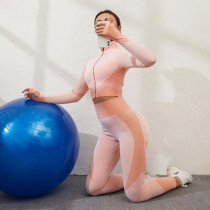 Frau in rosa nahtloser Sportleggings und Top mit Gymnastikball, Fitnessmode, Sportbekleidung.