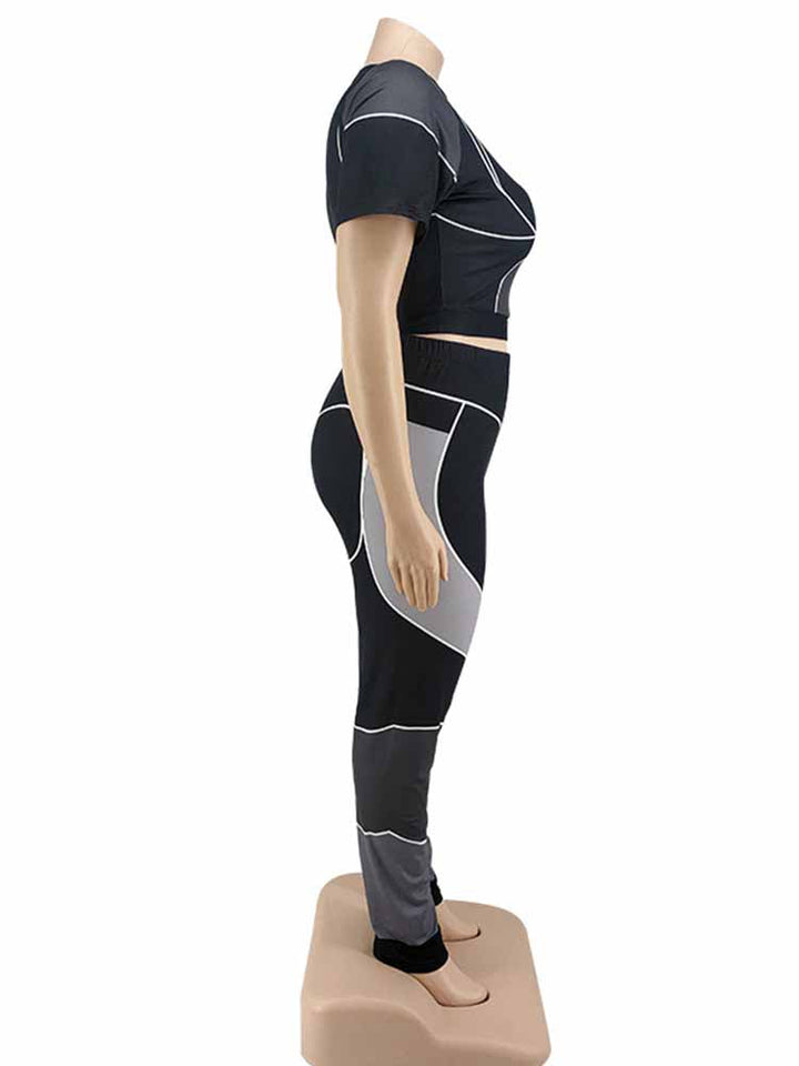 Schwarzes und graues Sport-Set für Damen, bestehend aus Crop-Top und Leggings, seitliche Ansicht.