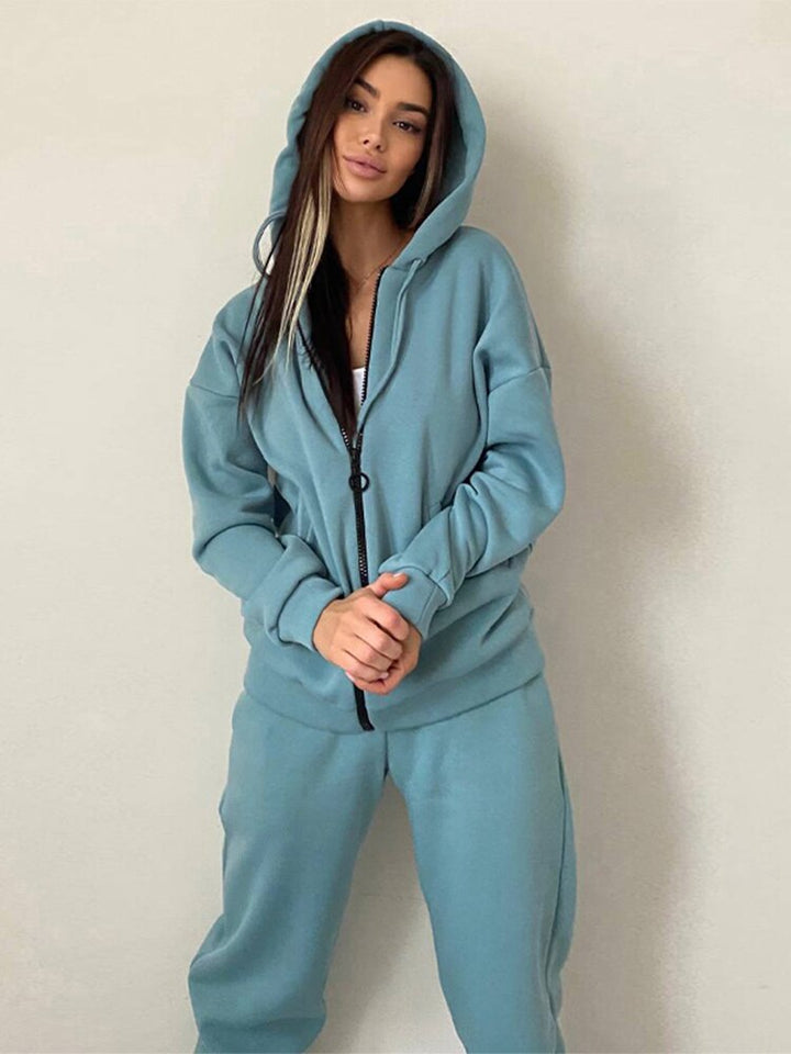 Frau in blauer Kapuzenjacke und Jogginghose, Freizeitmode, gemütlicher Stil.