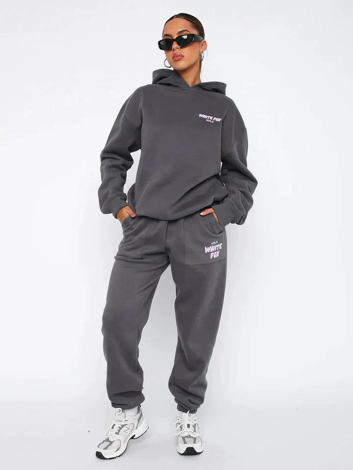 Frau in grauem Hoodie und Jogginghose, Sonnenbrille, sportlich, lässige Mode, Streetwear.