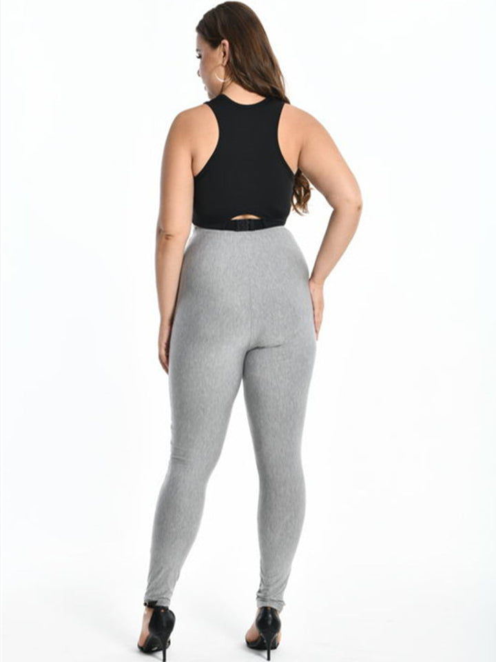 Frau in grauer Leggings und schwarzem Top, Rückansicht, Mode für große Größen, bequem, elegant.