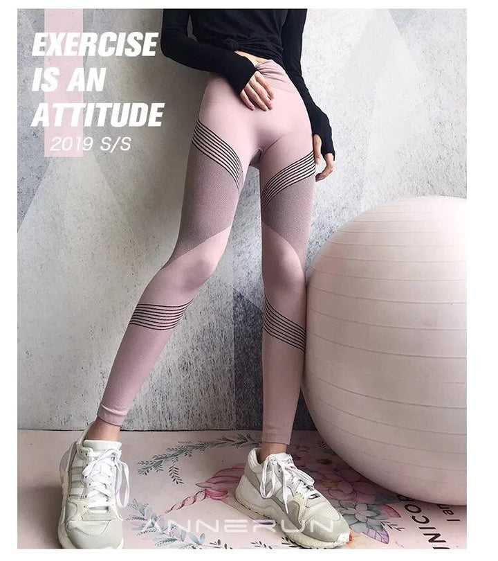 Frau in rosa Sportleggings mit Streifen, neben Gymnastikball, weiße Sneaker, Fitnessmode.
