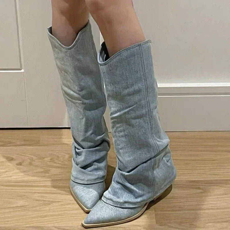 Graue Damenstiefel aus Denim, spitz zulaufend, knielang, modisch, auf Holzboden.