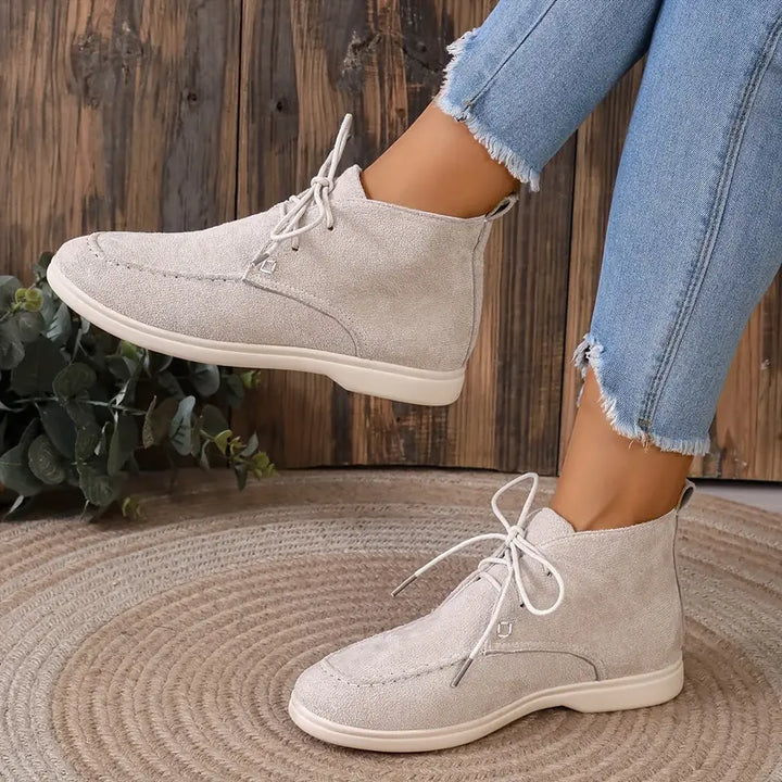 Damen Stiefeletten beige Wildleder, lässig, Schnürung, Jeans, Holzhintergrund, Mode.