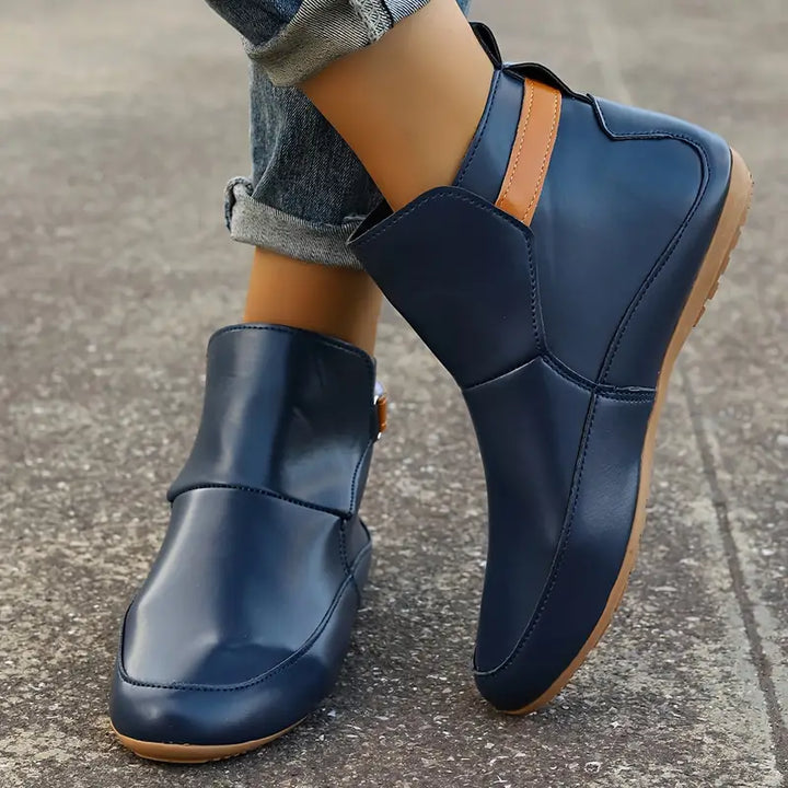 Blaue Lederstiefeletten für Damen, lässig, rutschfest, mit braunem Detail, Straßenszene.