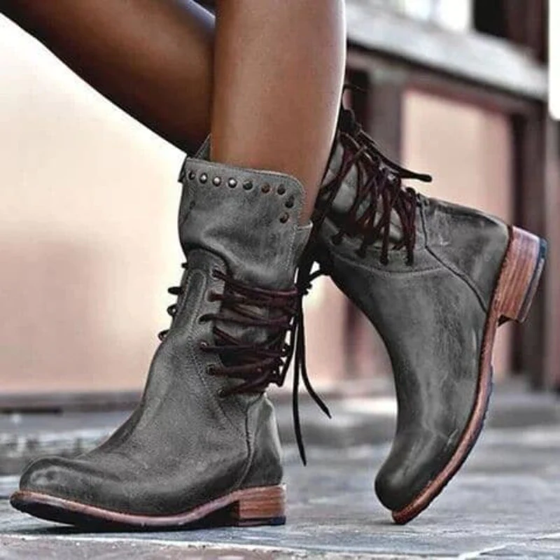 Damenstiefel aus grauem Leder mit Schnürung und Nieten, modisch und robust.
