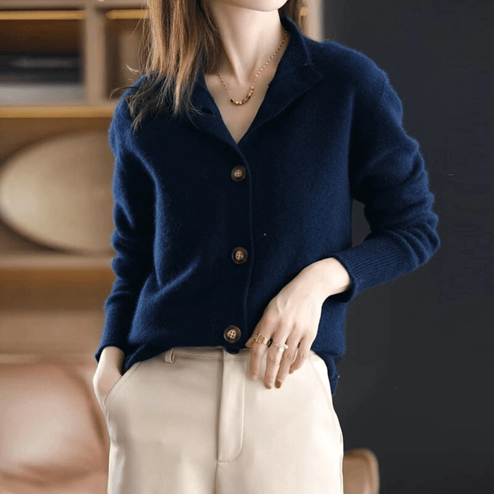 Dunkelblauer Damen-Cardigan aus Wolle mit Knöpfen, kombiniert mit beigen Hosen.