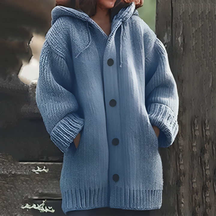 Frau in blauer Strickjacke mit Kapuze und Knöpfen, lässiger Herbstlook, gemütliche Mode.