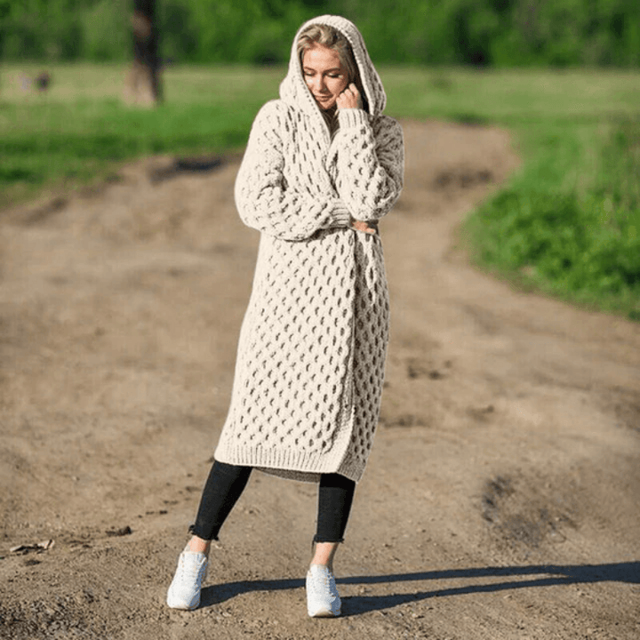 Frau in beigem Strickmantel mit Kapuze, lässig, übergroß, Herbstmode, draußen.