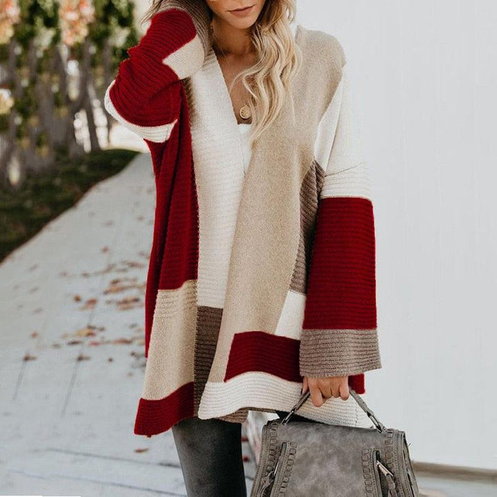 Frau in rot-beige gestreiftem Strickpullover, hält graue Handtasche, Herbstmode.