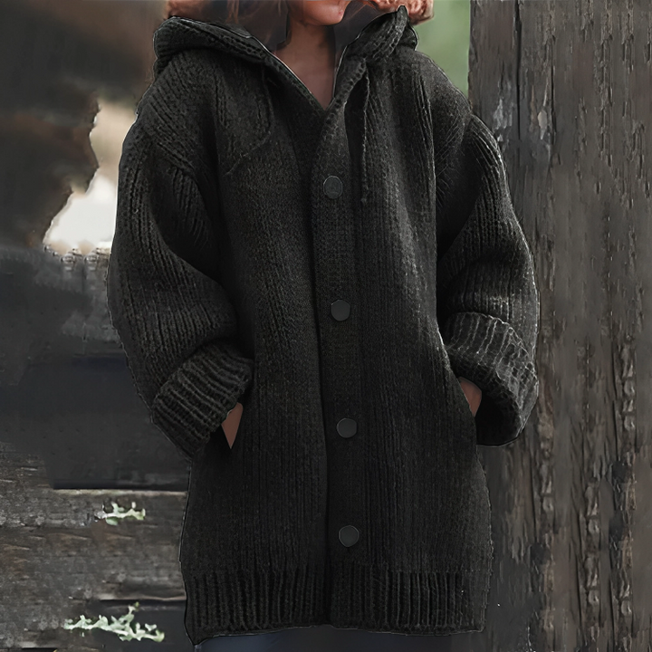 Frau in schwarzem Strickmantel mit Kapuze, Knöpfen und Taschen, Herbstmode, gemütlich.